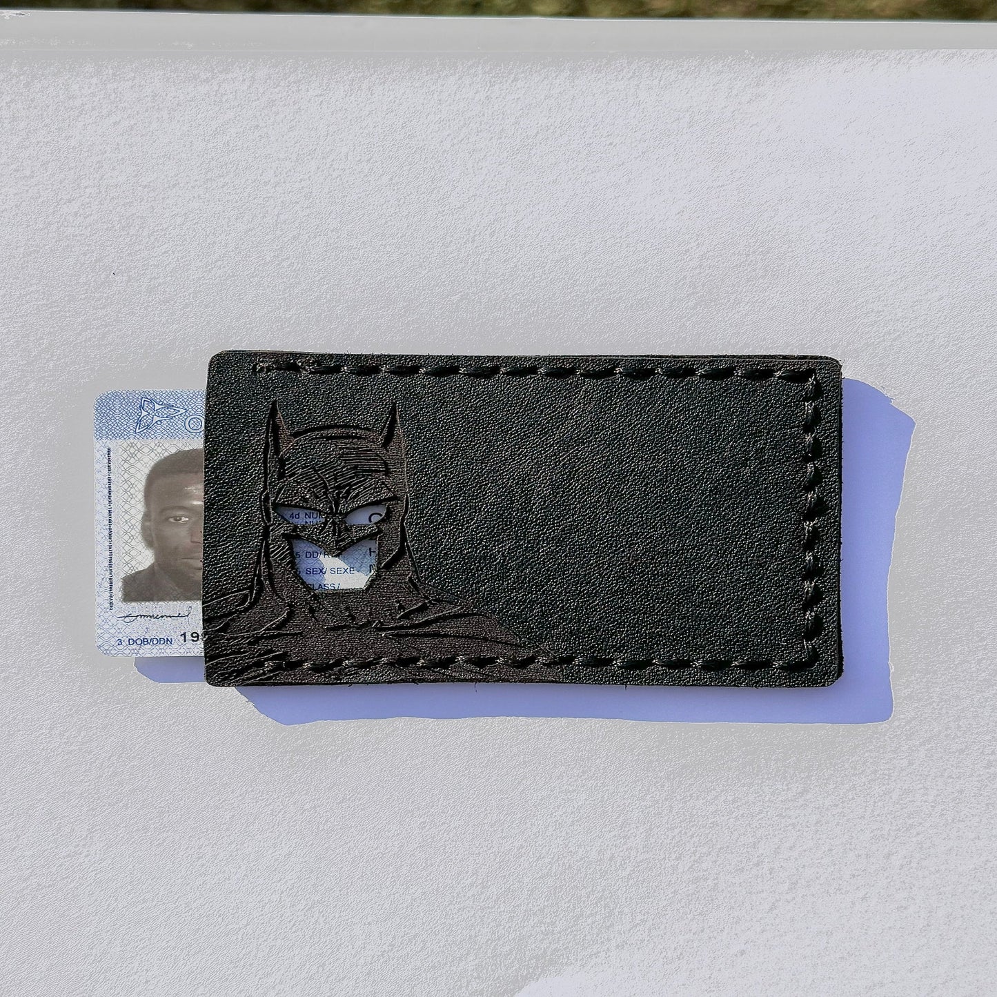 A black hand crafted batman id wallet with cut-out holes