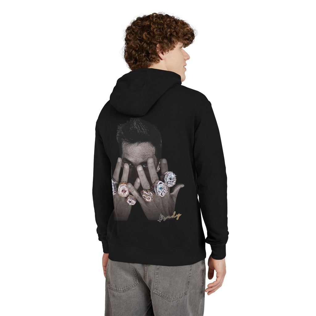 boy wearing a black hoodie with tom brady championship rings graphic design on the back