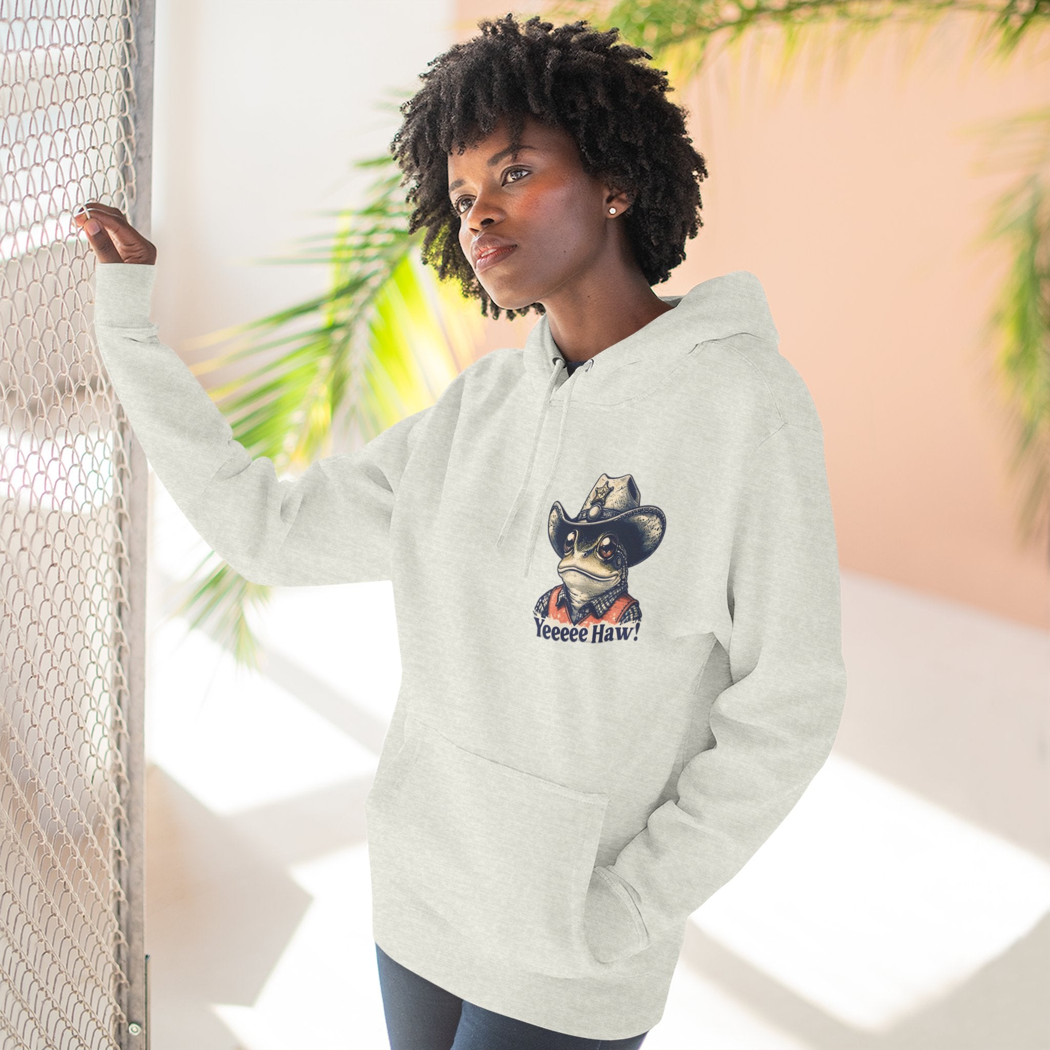 Person wearing a heather gray cowboy hoodie with a graphic design, standing against a neutral background.