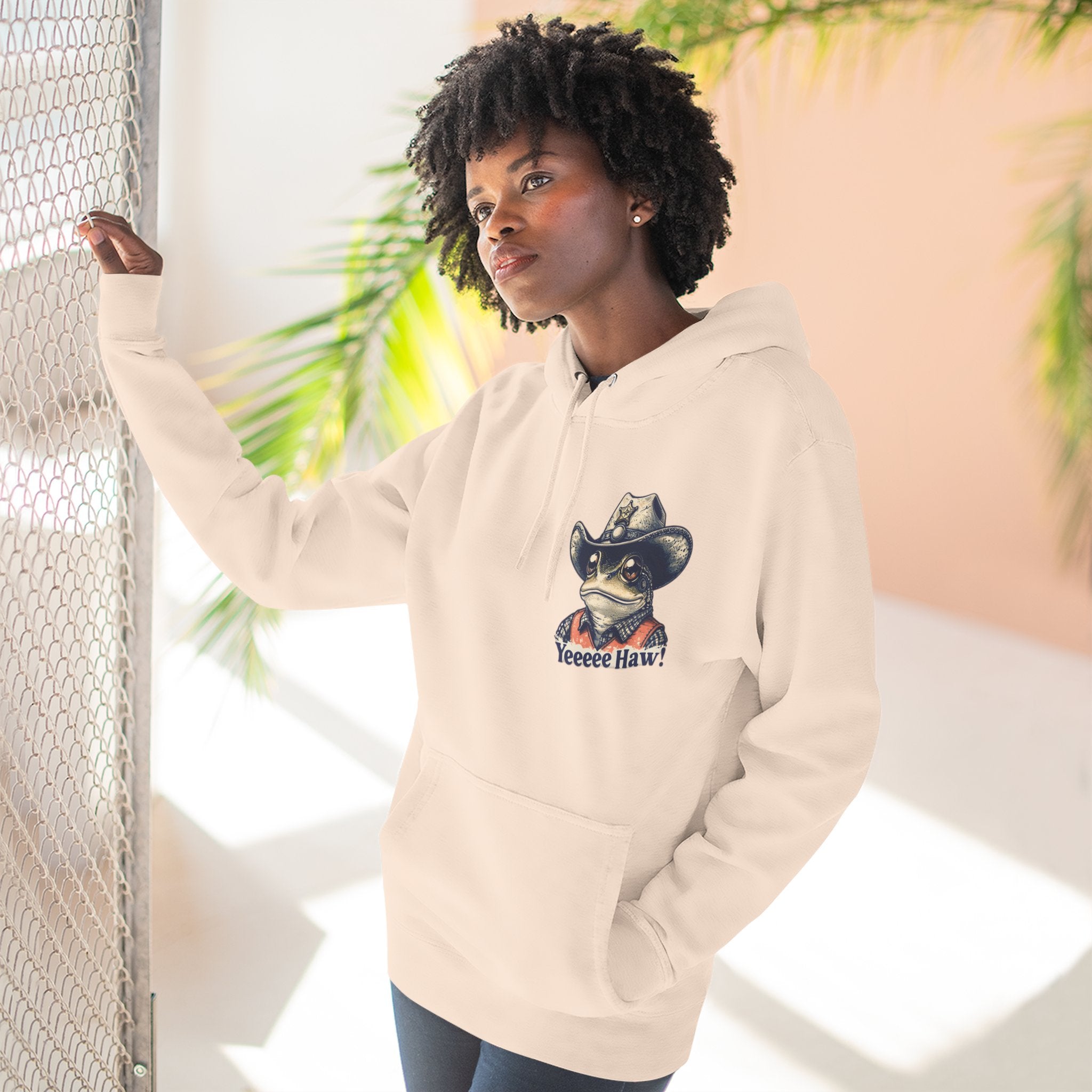 woman wearing a beige cowboy hoodie with a graphic design