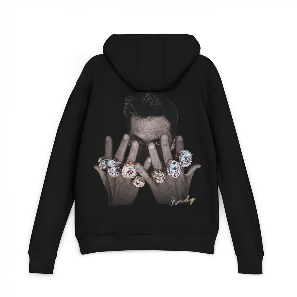 Black hoodie with a graphic of tom brady's hands holding rings on the back, displayed on a white background.