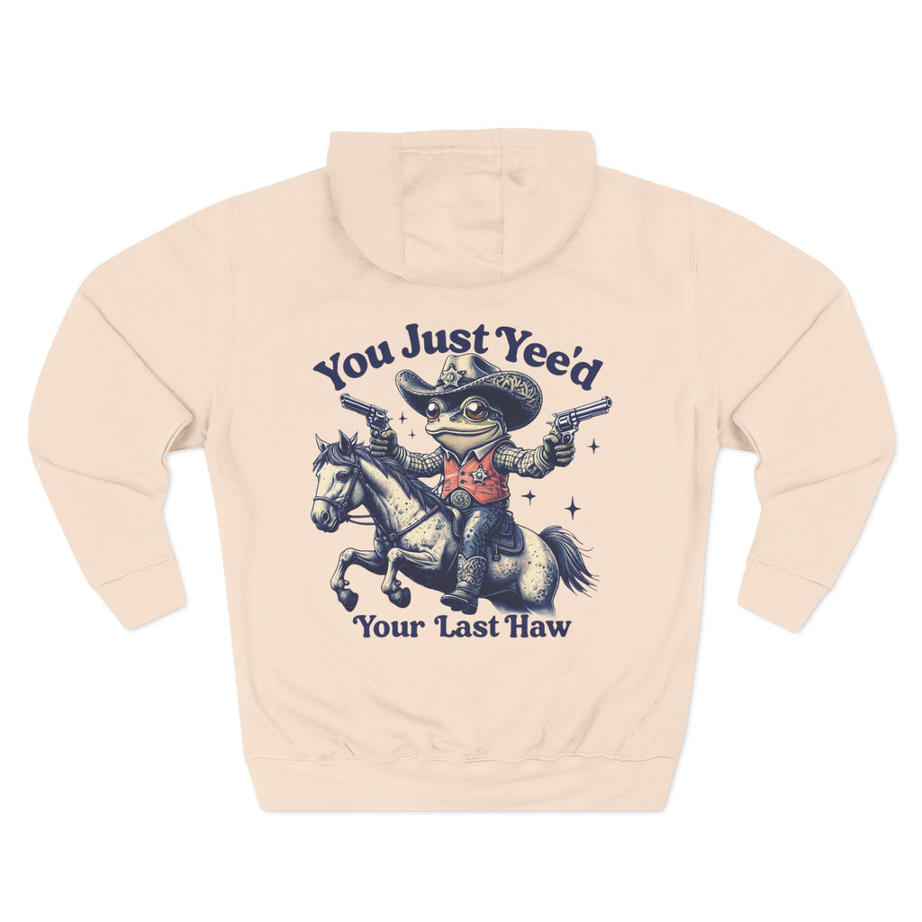 Beige cowboy hoodie with a graphic of a frog in a cowboy hat riding a horse and text on a white background
