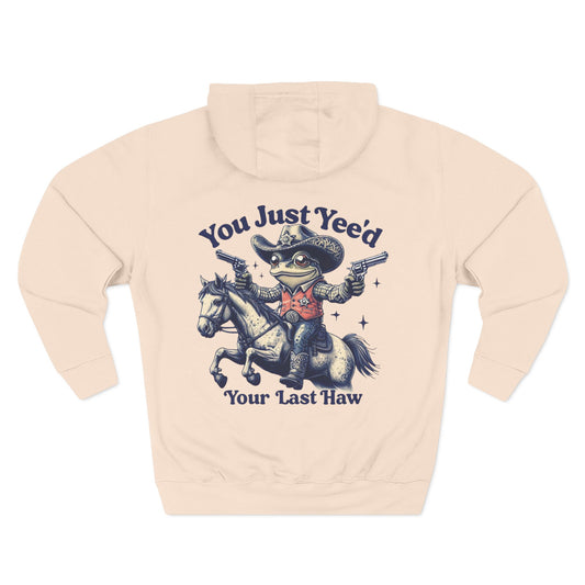 Beige cowboy hoodie with a graphic of a frog in a cowboy hat riding a horse and text on a white background