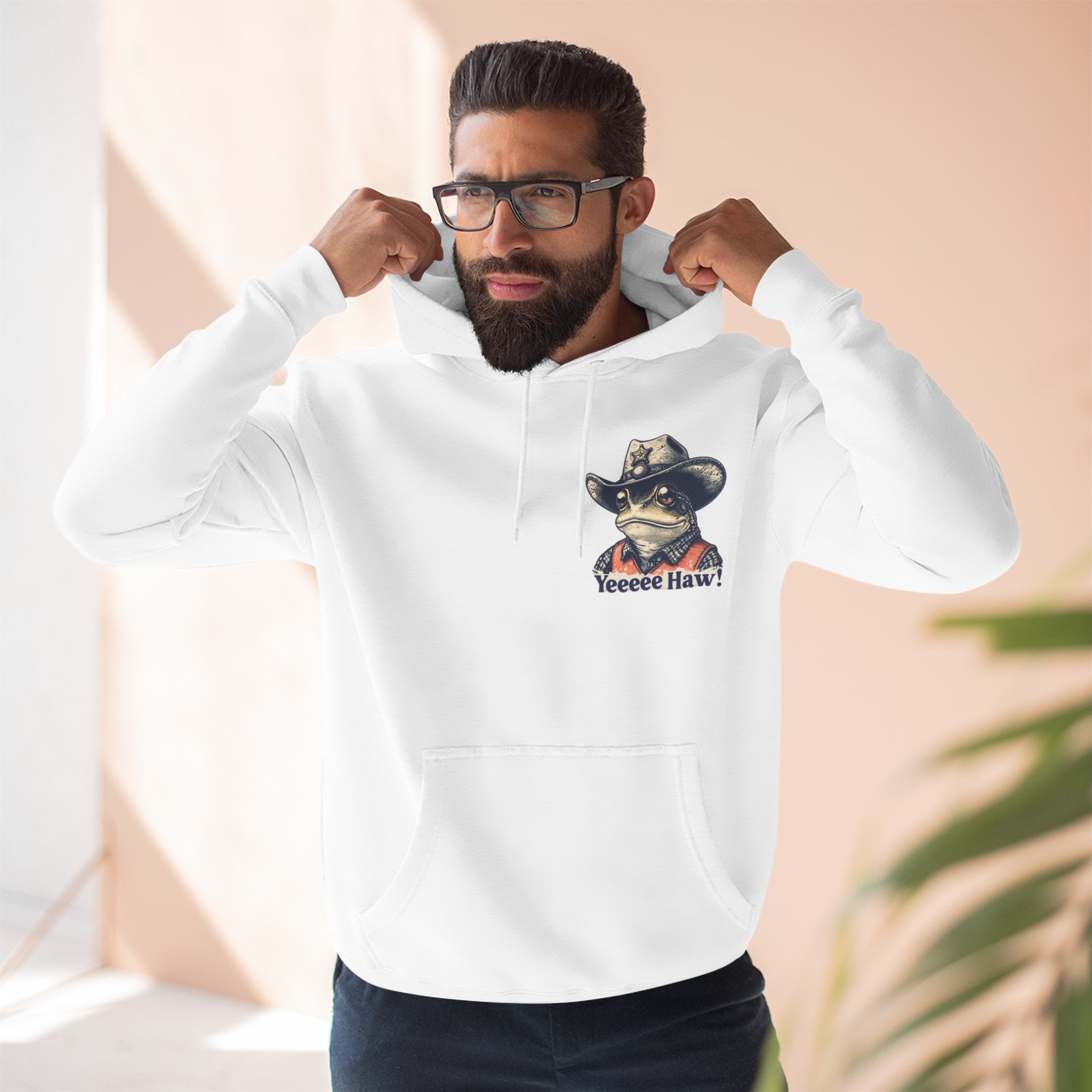 Man wearing a white cowboy hoodie with a graphic design on a light background